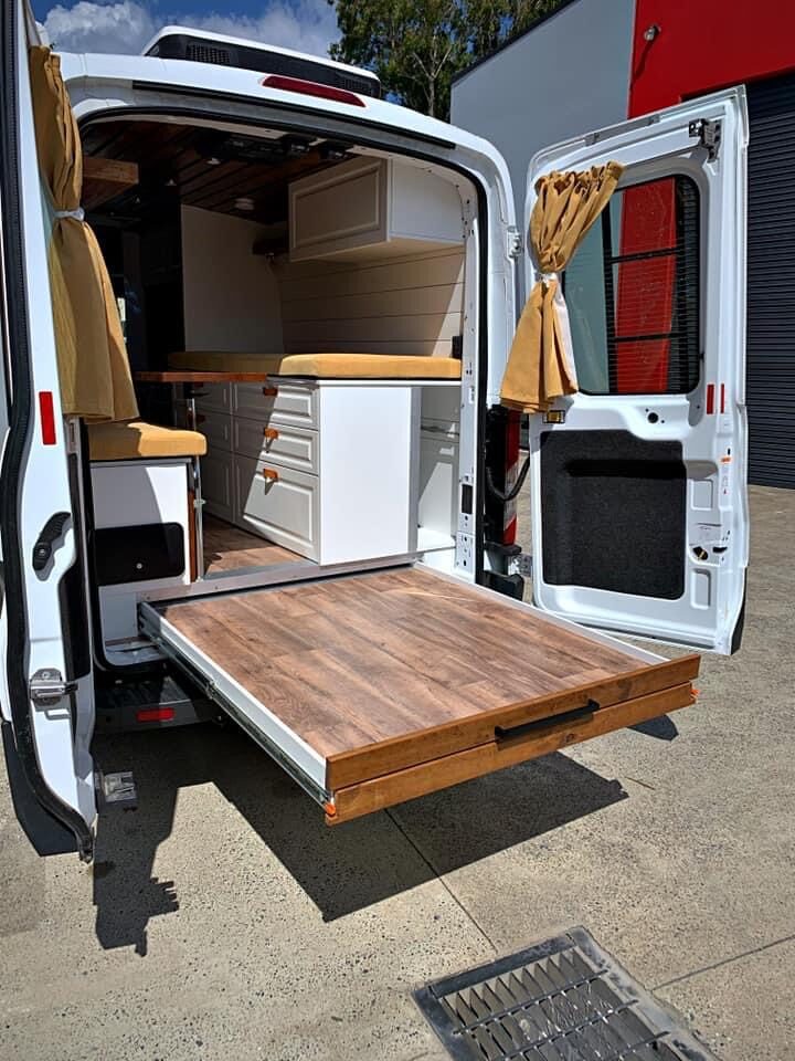 Rear slide-out deck and white cabinetry with mustard cushions