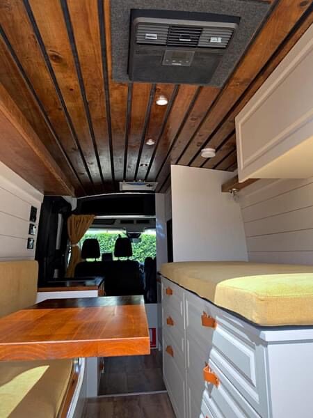 Finished interior looking forward, bed, storage and timber table