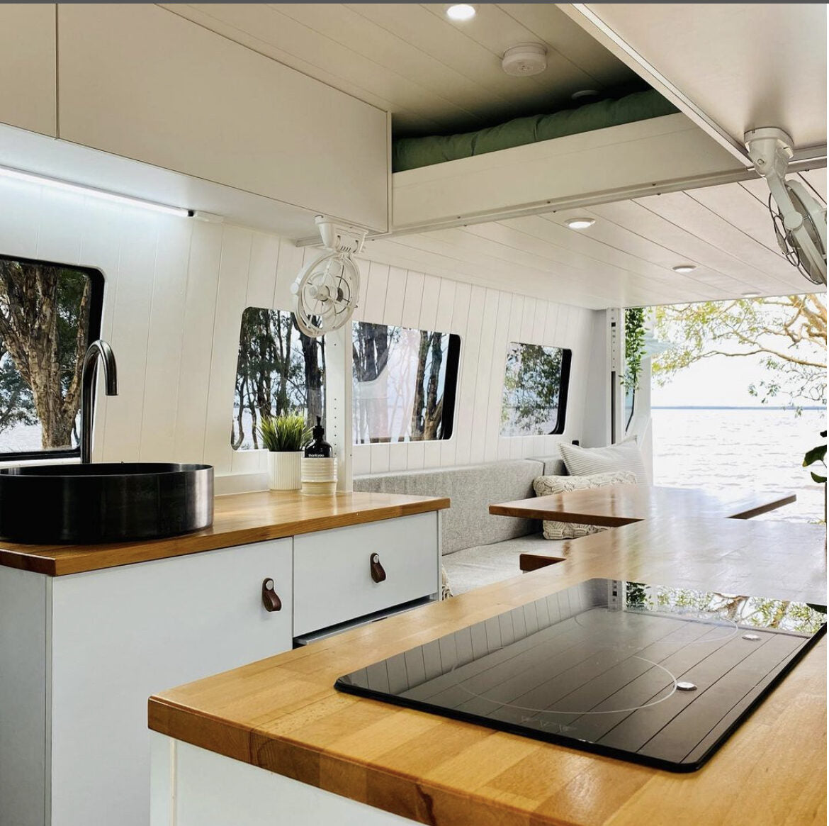 Kitchen with black sink and cooktop, dinette and lake view
