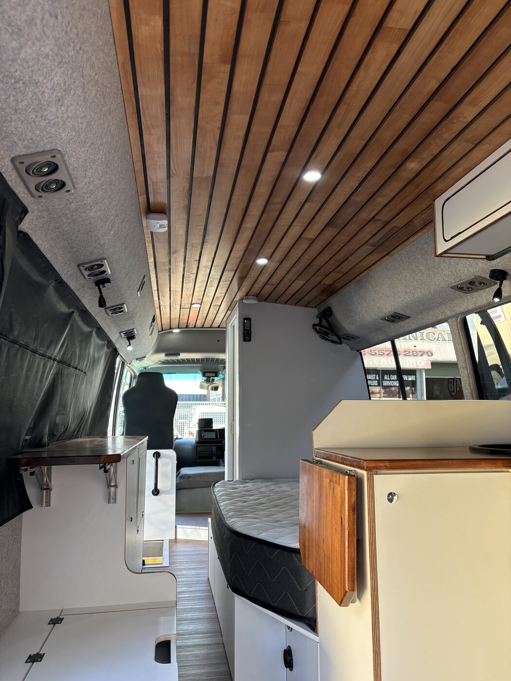Wood-slat ceiling, kitchen bench, bed and storage