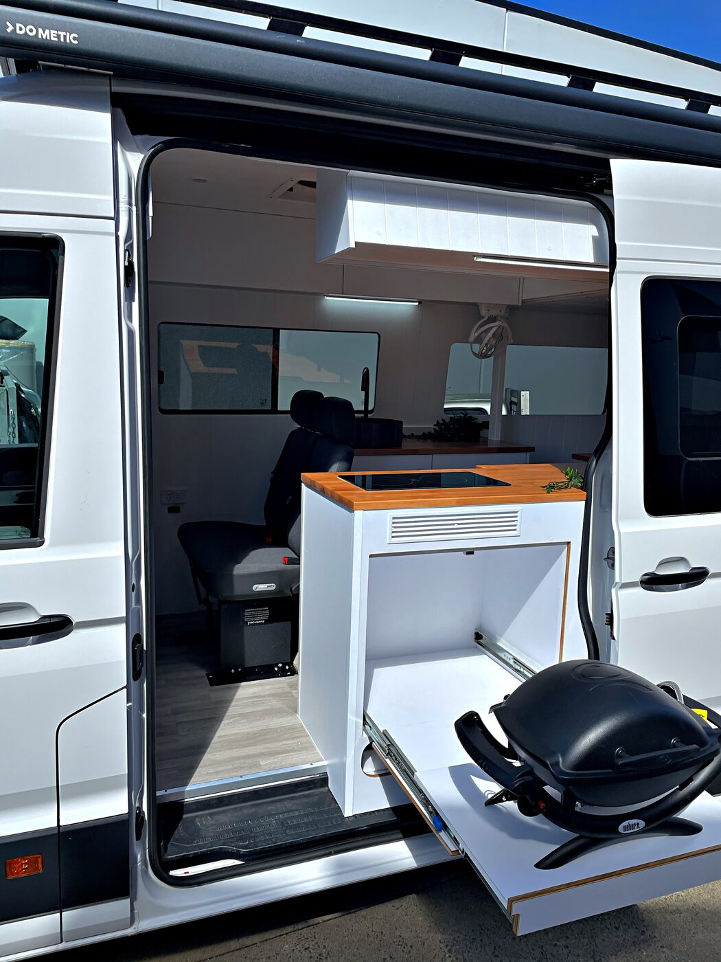 Side-door kitchen with slide-out tray and portable grill